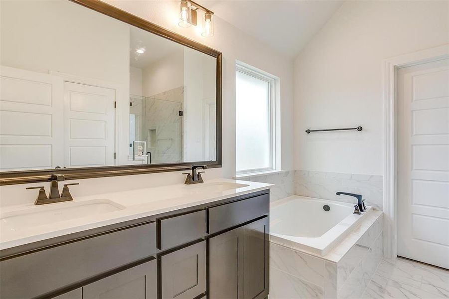 Bathroom featuring lofted ceiling, vanity, and plus walk in shower