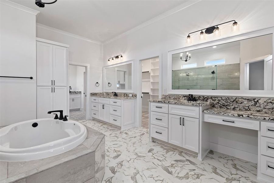 Bathroom with tile patterned flooring, independent shower and bath, vanity, and ornamental molding