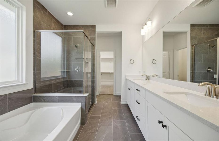 Elegant owner's bathroom with dual vanity and oversized shower*real home pictured