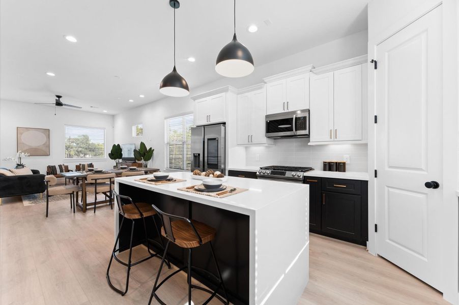 Contemporary three-story homes with sleek black and white exteriors, featuring spacious garages and modern design elements.