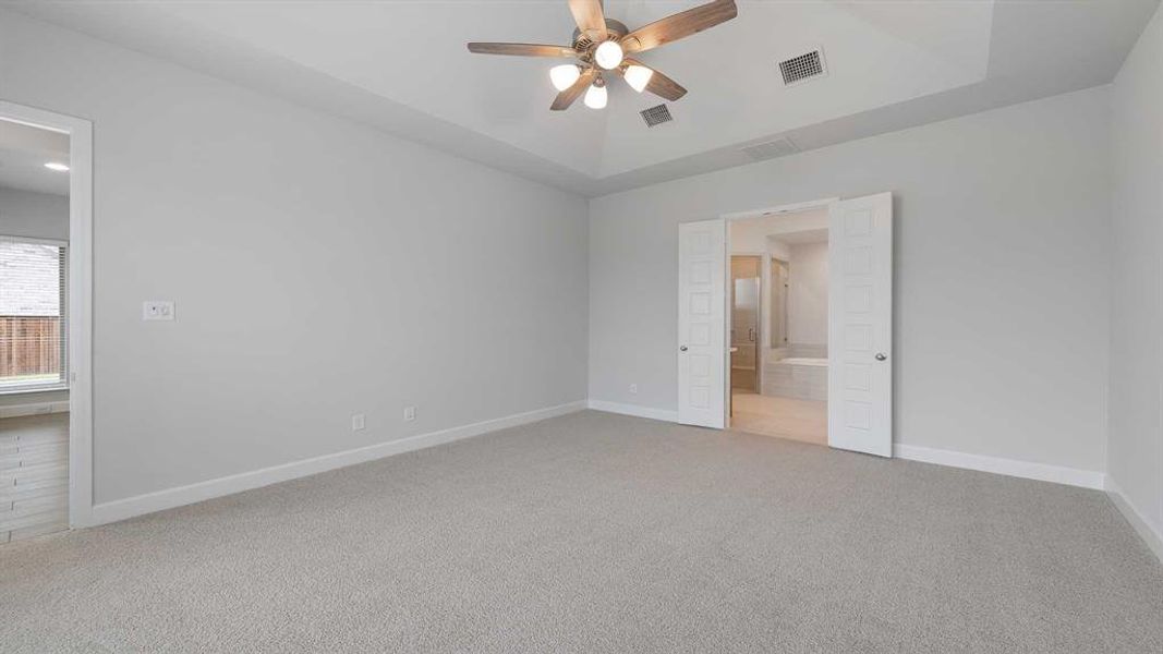 Carpeted spare room featuring ceiling fan