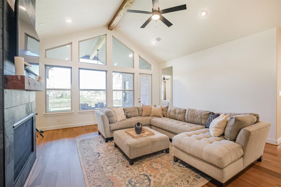 Cozy living area with tiled fireplace and stunning two-story windows.