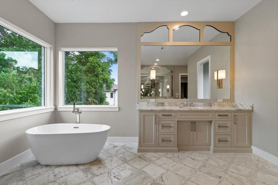 Inlaid marble floors and mirror design round out the primary bath space
