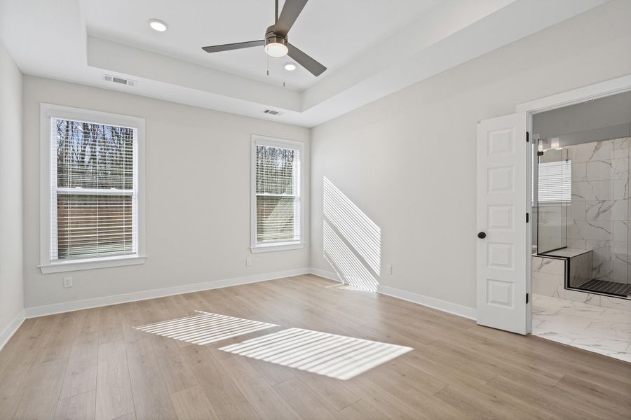 Spare room featuring a tray ceiling, light wood-style floors, ceiling fan, and recessed lighting Spare room featuring a tray ceiling, light wood-style floors, ceiling fan, and recessed lighting