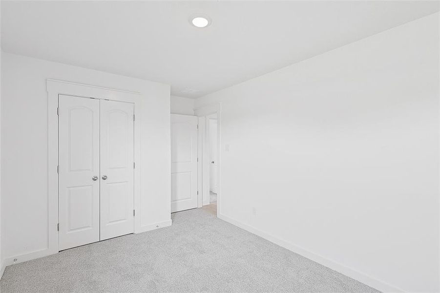 Unfurnished bedroom with a closet and light colored carpet