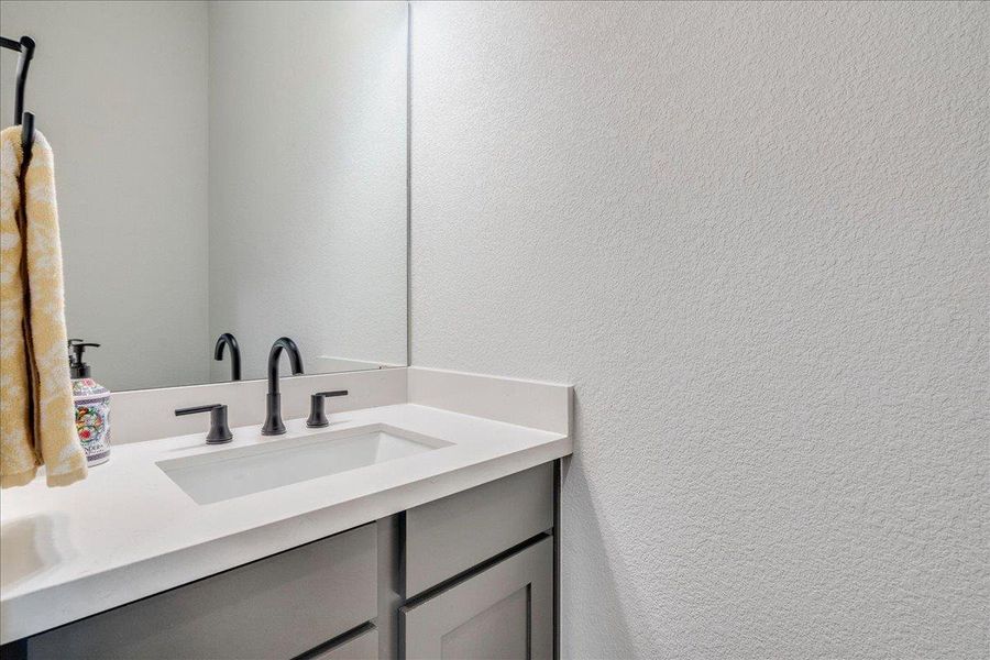 Bathroom with vanity and a textured wall