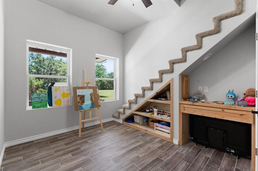 Bedroom #3 with closet, ceiling fan, windows for natural lighting, built in knotty alder desk and shelving, with stairs to access loft area.