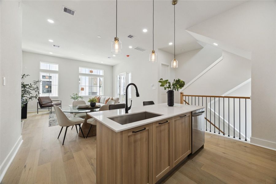 Modern open-concept kitchen, dining, and living area with sleek finishes and abundant natural light.