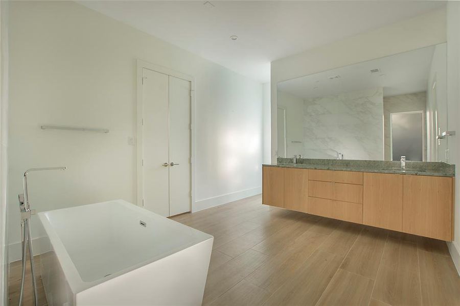 Bathroom with hardwood / wood-style floors, vanity, and shower with separate bathtub