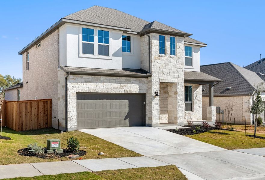 Front exterior of a new home in Heritage, Dripping Springs, TX, highlighting curb appeal (Image 2). Front exterior of a new home in Heritage, Dripping Springs, TX, highlighting curb appeal (Image 2).
