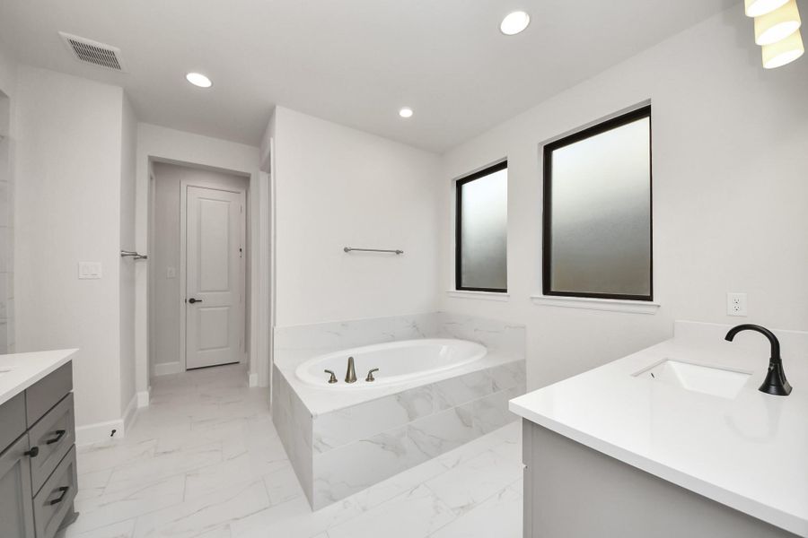 Spacious layout with soaking tub, dual vanities, and natural light.