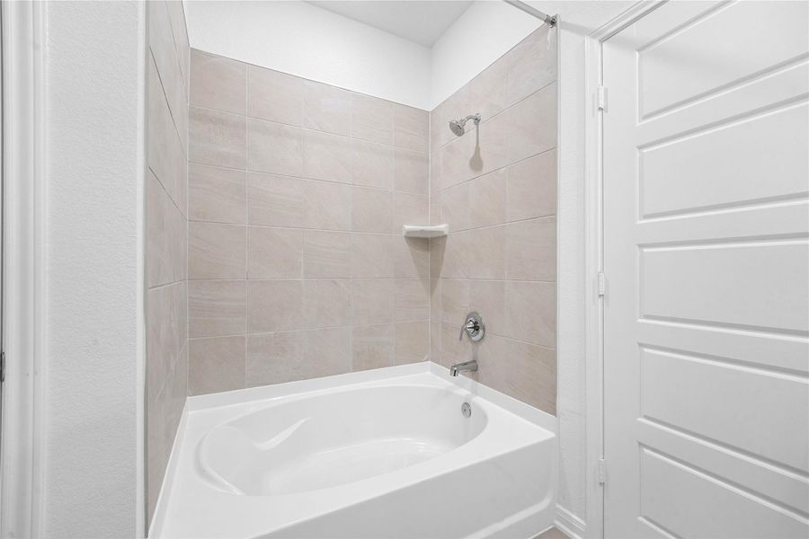 This view highlights the primary bathroom's versatile tub/shower combination, thoughtfully designed to accommodate both a quick, invigorating morning shower and a luxurious, deep soak after a long day.