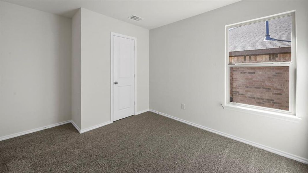 Unfurnished bedroom featuring baseboards and dark carpet