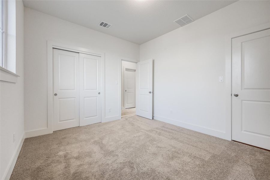 Unfurnished bedroom featuring carpet floors and a closet Unfurnished bedroom featuring carpet floors and a closet