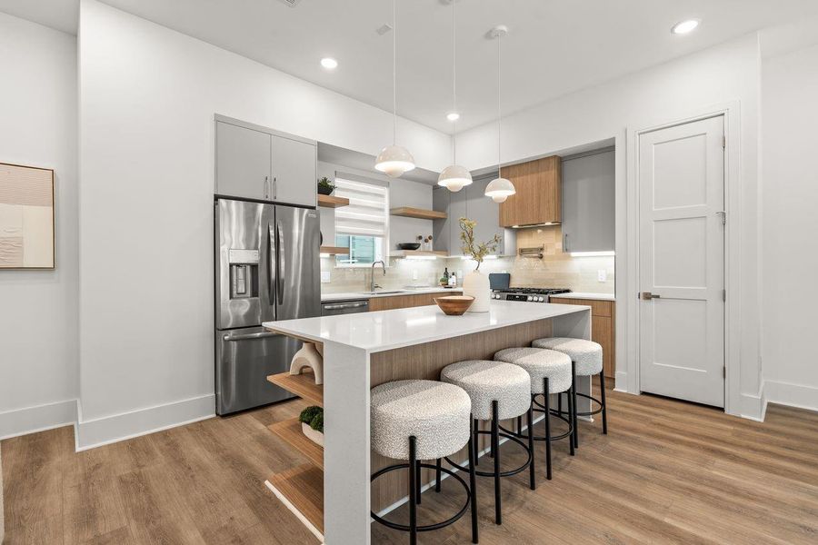 Layered cabinetry and open shelving bring dimension to the space while the interplay of texture, tone, and proportion lends the kitchen a quiet sophistication, allowing each material to contribute cohesively.