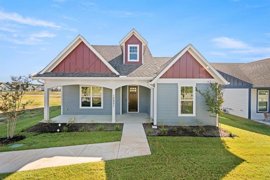 View of front of home with a front yard and covered porch