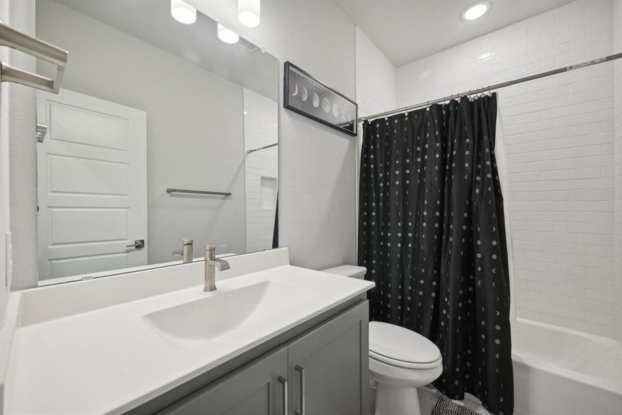 Full bathroom with shower / bath combo, toilet, and vanity