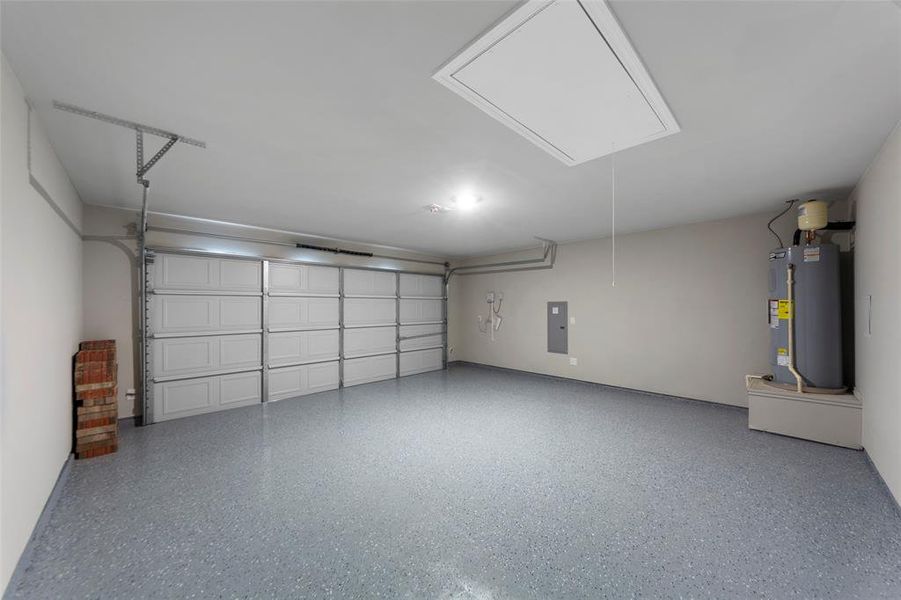 Two-car garage featuring a gray epoxy floor coating, painted walls, and a white panel garage door