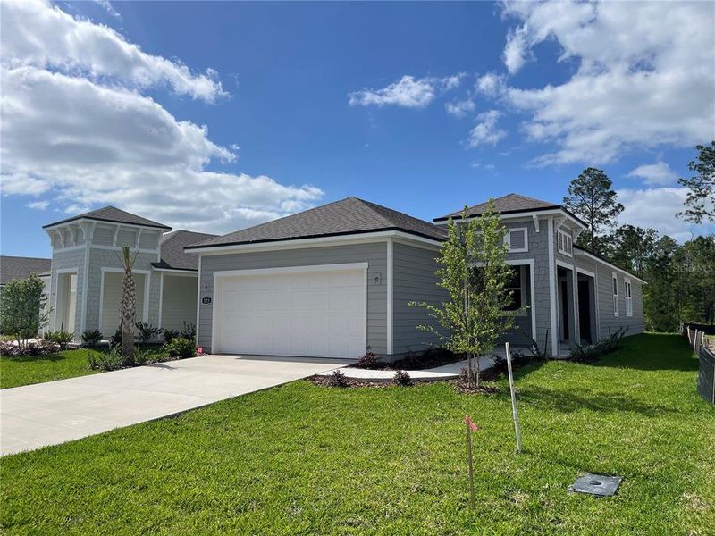 Front exterior of a new home in Palm Series at Seminole Palms, Palm Coast, FL, highlighting curb appeal (Image 16).
