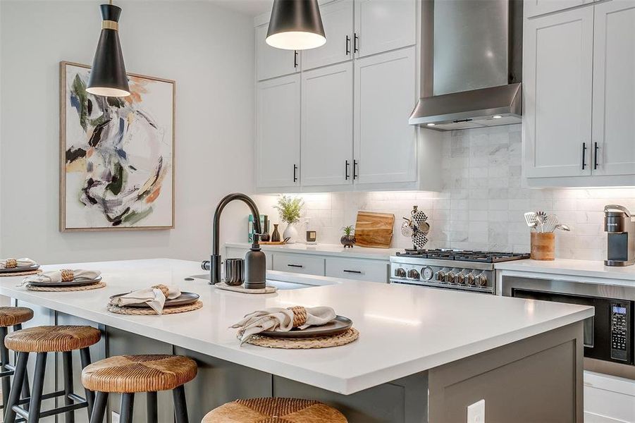Kitchen featuring wall chimney exhaust hood, decorative backsplash, white cabinets, built in microwave, and stainless steel range with gas cooktop Kitchen featuring wall chimney exhaust hood, decorative backsplash, white cabinets, built in microwave, and stainless steel range with gas cooktop