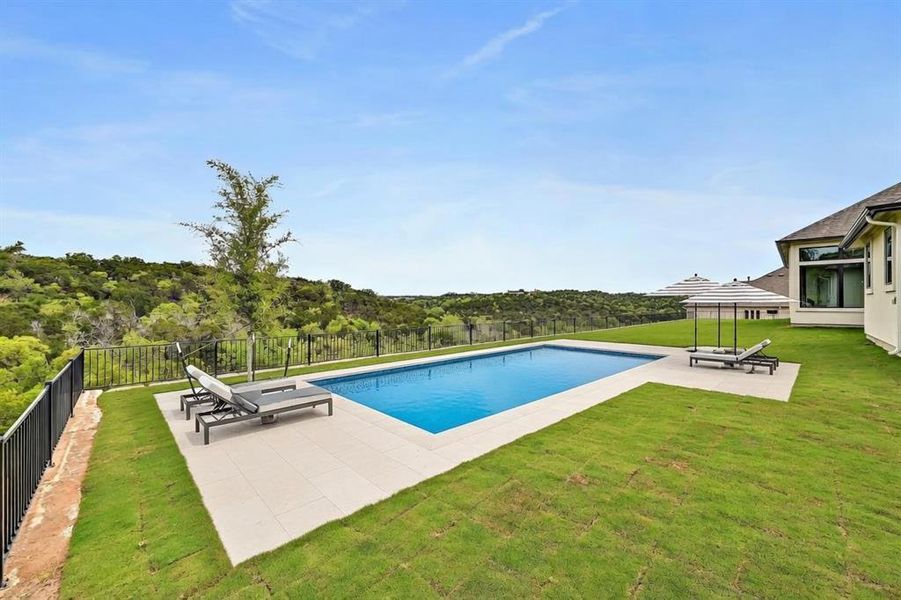 (Virtual Photo) An inviting backyard oasis features a glistening in-ground pool, expansive green lawn, and panoramic tree-filled views. (Virtual Photo) An inviting backyard oasis features a glistening in-ground pool, expansive green lawn, and panoramic tree-filled views.