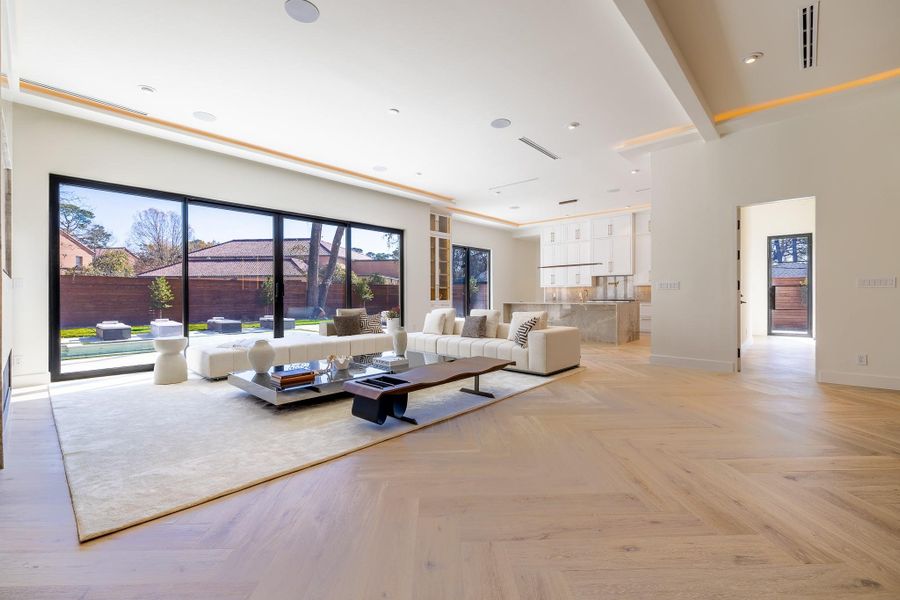 Expansive living room with floor-to-ceiling glass overlooking the backyard and pool. Expansive living room with floor-to-ceiling glass overlooking the backyard and pool.