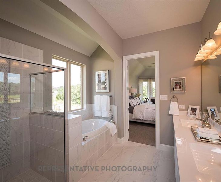 Ensuite bathroom with a stall shower, double vanity, a bath, lofted ceiling, and marble finish floors Ensuite bathroom with a stall shower, double vanity, a bath, lofted ceiling, and marble finish floors