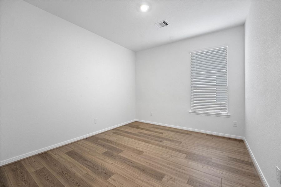 The Den is a versatile and additional living space that can be used as a home office, hobby or play room. It features Bandera vinyl plank flooring in Light Pine, high ceilings, large window with privacy blinds and neutral paint.