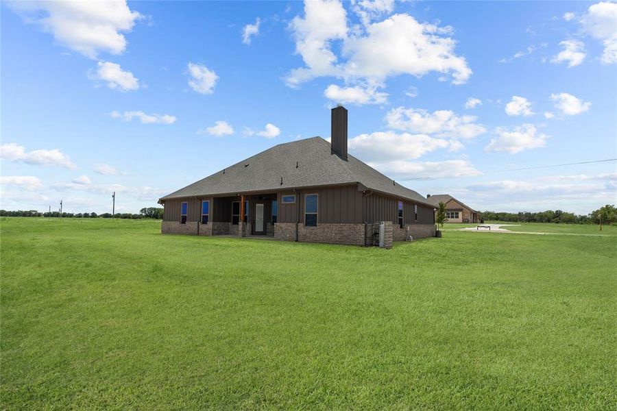 Back of house with a lawn