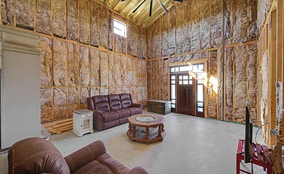 Living area featuring high vaulted ceiling and concrete flooring Living area featuring high vaulted ceiling and concrete flooring