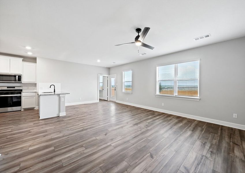 The large family room has large windows and a view of the back yard.