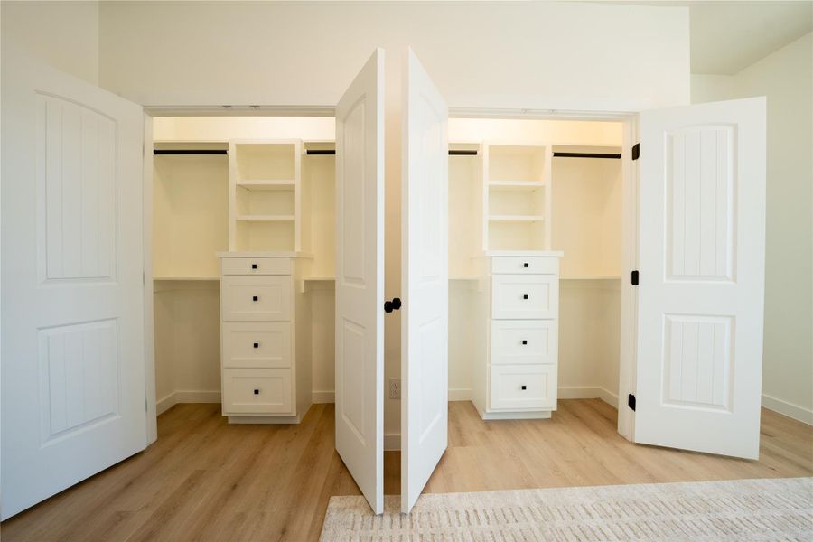 Double custom built closets in Primary
