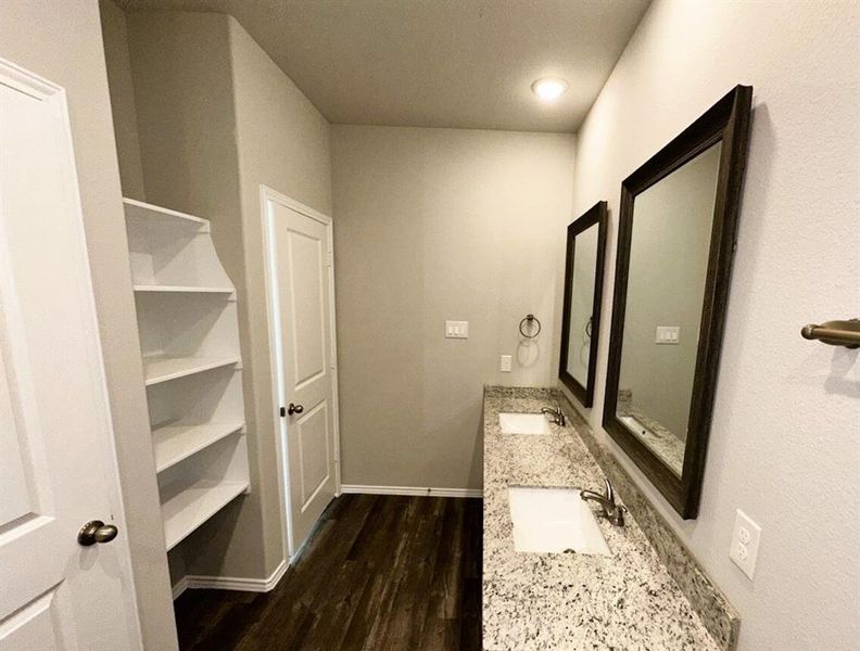 Double sinks, granite counters, framed mirrors, shelving- this master bath has everything!