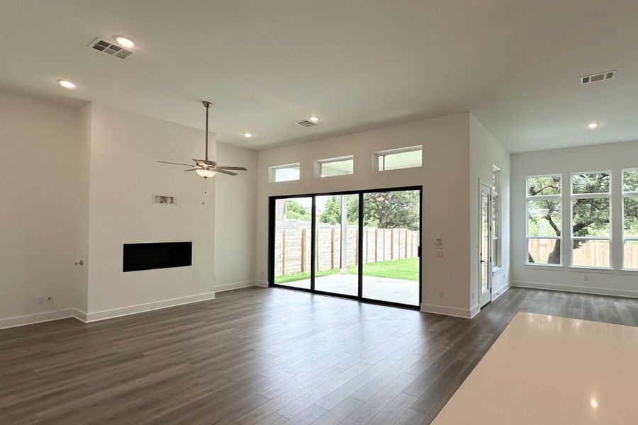 A great room with high ceilings, recessed lighting, and expansive sliding doors opening to a private yard.