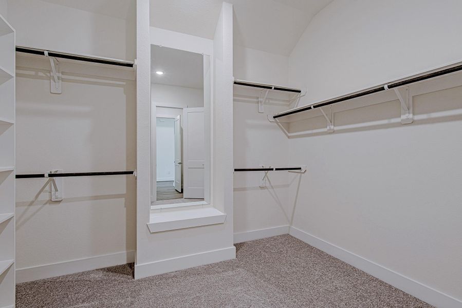Spacious walk-in wardrobe with built-in shelving and hanging space Spacious walk-in wardrobe with built-in shelving and hanging space