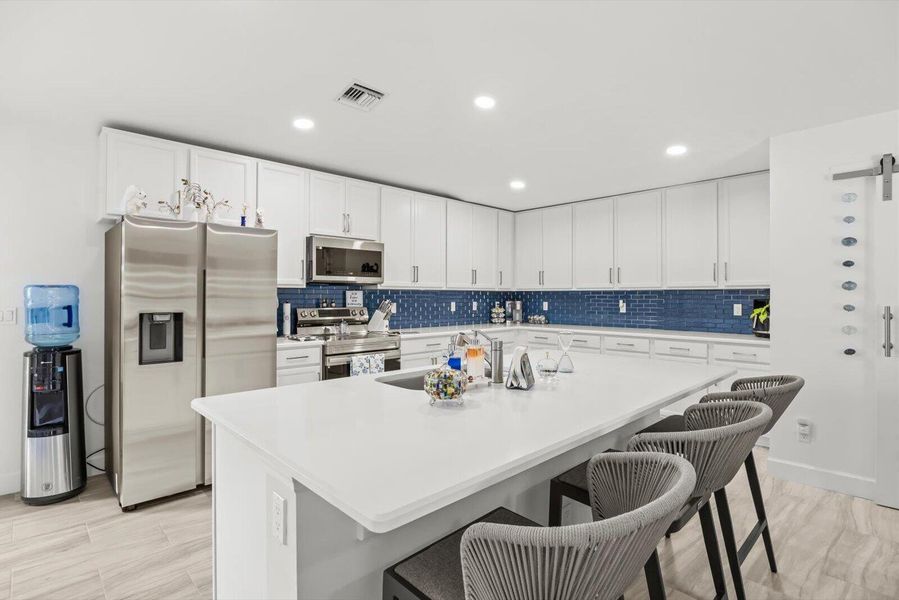 Modern L-Shaped Kitchen Design with Ample Counter Space and Seating