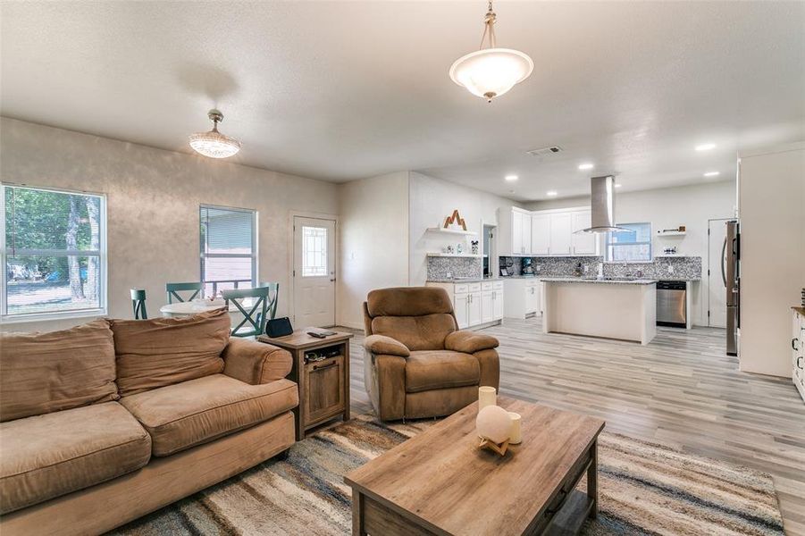 Living room with light wood-type flooring and recessed lighting Living room with light wood-type flooring and recessed lighting