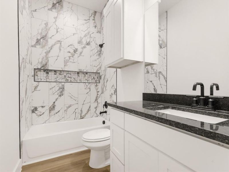 Bathroom with shower / tub combination, vanity, and light wood finished floors