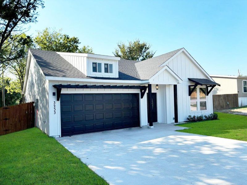 Modern inspired farmhouse with a garage and a front yard