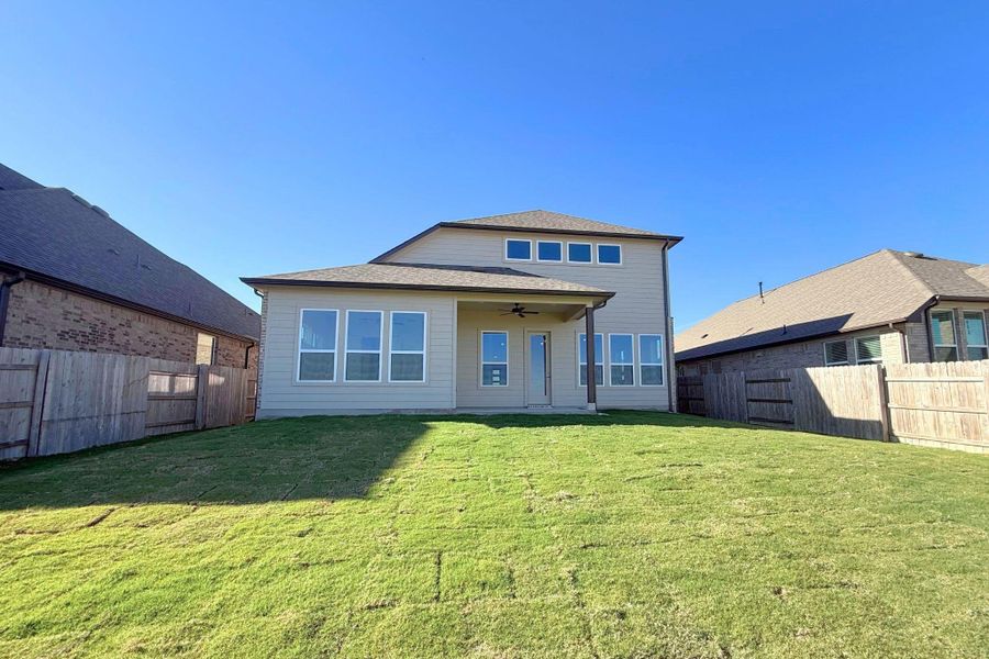 Rear view of house featuring a ceiling fan, a fenced backyard, and a patio