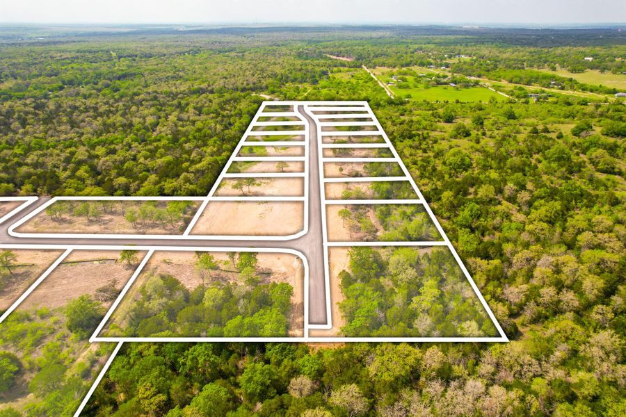 Aerial view of a new residential development nestled amidst verdant, mature trees.