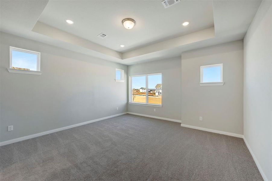 Spare room with dark carpet, recessed lighting, and a tray ceiling