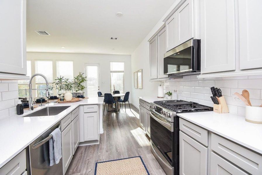 A bright, polished kitchen with ample counter space and stainless style finishes ready for cooking or hosting.