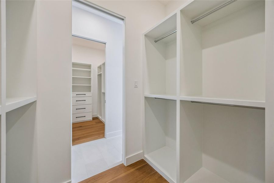 The primary suite features dual walk-in closets designed with built-in shelving and additional storage throughout. Connected closet spaces create a functional layout while keeping organization easily accessible day to day. The primary suite features dual walk-in closets designed with built-in shelving and additional storage throughout. Connected closet spaces create a functional layout while keeping organization easily accessible day to day.