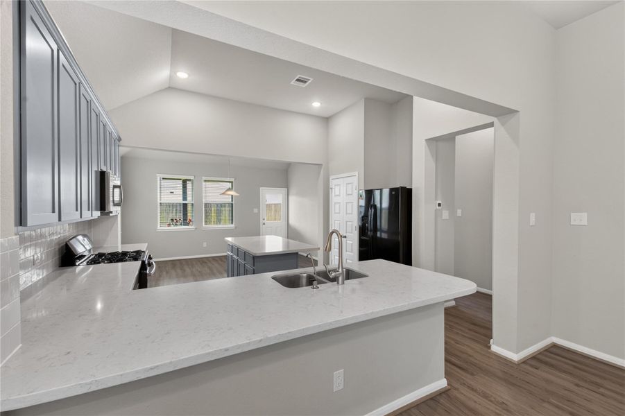 This spacious living area features high ceilings, a ceiling fan, and ample natural light from multiple windows. The room has elegant wood-look flooring and neutral walls, offering a versatile space for personalization. This spacious living area features high ceilings, a ceiling fan, and ample natural light from multiple windows. The room has elegant wood-look flooring and neutral walls, offering a versatile space for personalization.