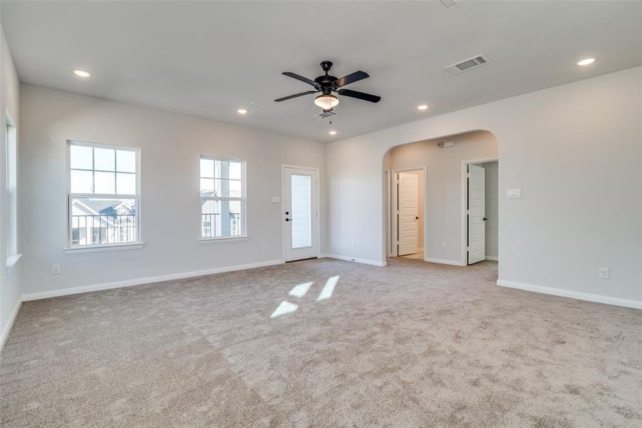 Empty room with ceiling fan and light colored carpet