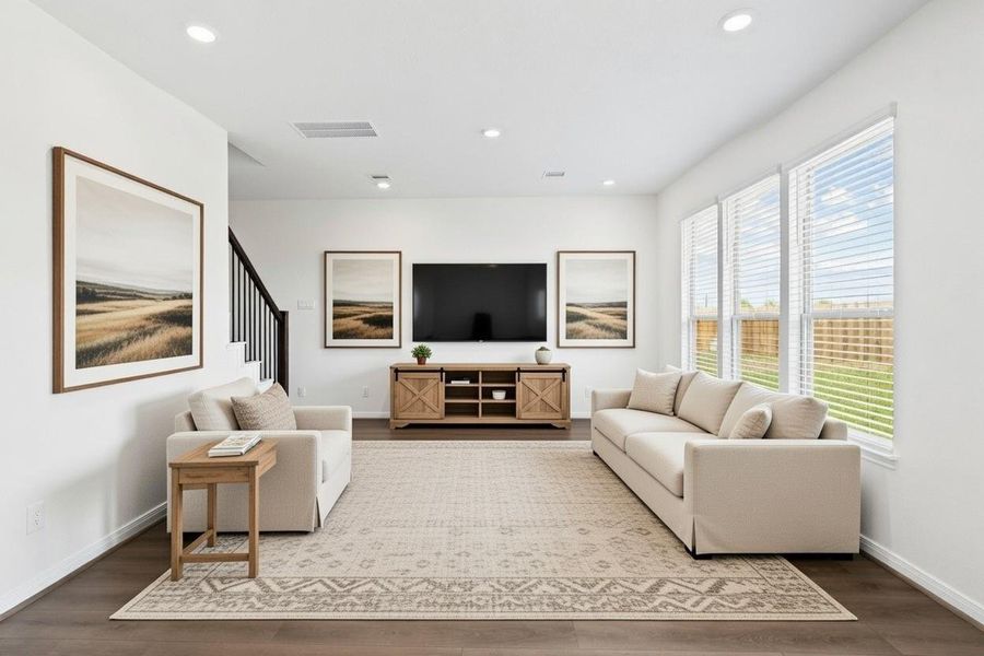 This bright and airy Great Room offers a spacious layout ideal for both relaxing evenings and lively gatherings. Designed for comfort and connection, it features Layton Lake vinyl plank flooring, large windows with blinds, high ceilings, recessed lighting, and seamless access to the stunning kitchen and dining—perfect for everyday living and entertaining alike.