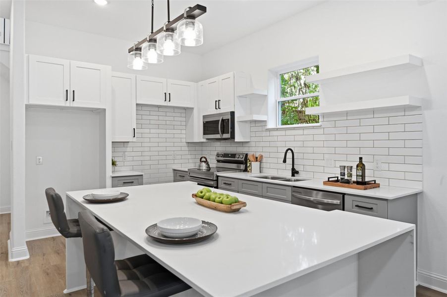 Open concept kitchen, dining and living room, with lots of natural light.