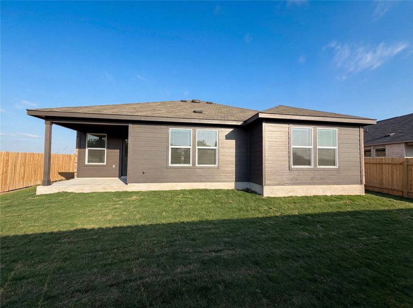 Back of property with a fenced backyard, a patio area, and a shingled roof