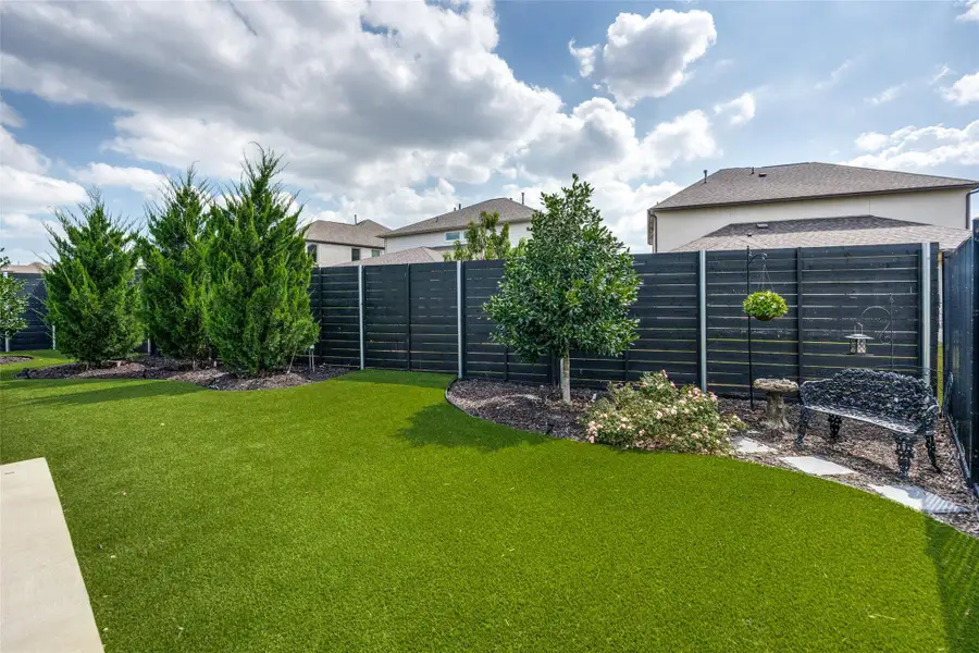Manicured landscaping and privacy fencing frame this low-maintenance outdoor space under open skies.